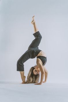 a woman is doing a handstand on the floor