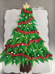 a christmas tree made out of paper on top of a plastic container with red ribbon