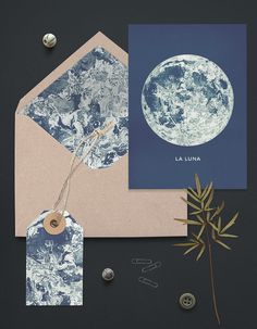 an envelope with a blue moon on it and some other items to make it look like they are floating in the air