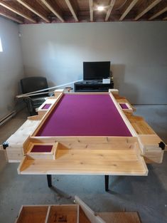 a pool table with purple felt on it in a room that is being constructed into an office