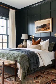 a bedroom with dark green walls, white bedding and rugs on the floor