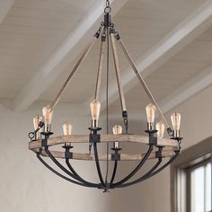 a wooden chandelier with six lights hanging from it's center beam in an empty room