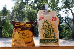 two bags of masa de maiz sitting on a wooden table next to each other