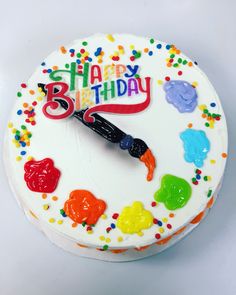 a birthday cake with white frosting and multicolored candies