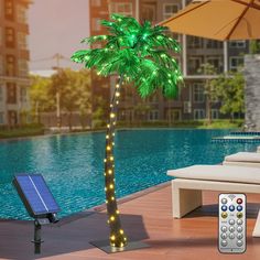 a lighted palm tree next to a pool with a remote control in front of it