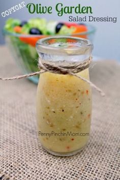 a jar filled with salad dressing sitting on top of a table