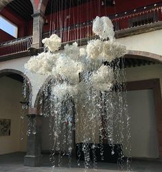 a large chandelier with white flowers hanging from it's sides in a building