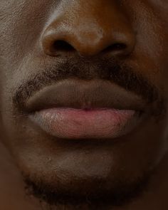 a close up of a man's face with dirt on his lips