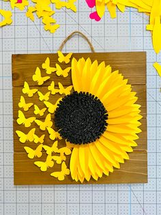 a sunflower is surrounded by butterflies on a cutting board