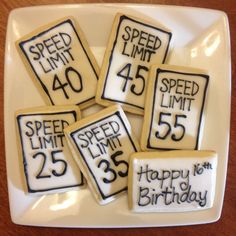 birthday cookies decorated with the speed limit and happy birthday messages on them are arranged in a square white plate