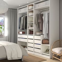 a bedroom with a bed, chair and closet in the corner next to a window