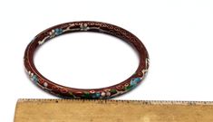 This is a beautiful Asian floral enamel on a metal Cloisonne bracelet. The orange-red maroon enamel has green and blue pink and black flowers on it. There is a gold gilt trim to the bracelet. the floral design is on both the exterior and interior of this bangle, The width is 1/4 inch. the circumference is 8 inches. This Chinese hinged flower bracelet good vintage condition with age appropriate wear Thank you very much for stopping by . Please feel free to email (CONVO) me with any questions or c Red Enamel Bangle Jewelry, Adjustable Enamel Bangle, Red Enamel Bangle, Red Enamel Bangle Bracelet, Red Enamel Bangle Bracelets, Cloisonne Bracelet, Bracelet Stacking, Maroon Red, Enamel Bracelet