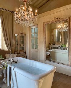 a bathroom with a claw foot tub and chandelier in the middle of it