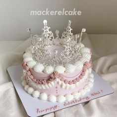 a pink and white cake with a tiara on top