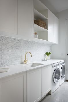 a kitchen with white cabinets and a washer and dryer