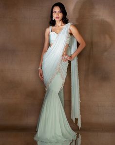 Mint georgette fishtail sari featuring an attached pre-draped pallu hand embellished with ivory pearls & glass beads & tassles. Paired with a stylised organza crop with embellished straps & an oversized bow at the back.From Shloka Khialani's Winter Sun collection.DELIVERY TIMEPlease allow 6-8 weeks for your outfit to arrive.FABRIC DETAILSGeorgette, Organza, CrepeProfessional cleaning only. Festive Floor-length Pre-draped Saree For Gala, Festive Embellished Pre-draped Saree, Embellished Pre-draped Saree For Wedding, Festive Embellished Pre-draped Saree For Gala, Traditional Pre-draped Saree With Pearl Embroidery For Evening, Festive Georgette Gown For Gala, Festive Saree For Gala, Floor-length Sheer Dupatta Pre-draped Saree For Reception, Hand Embellished Organza Pre-draped Saree