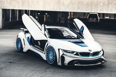 a white and blue bmw sports car parked in a parking lot with its doors open