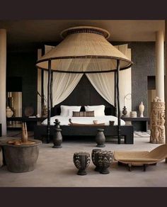 a canopy bed sitting in the middle of a room next to two chairs and tables