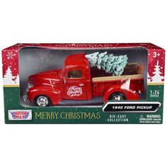 a red truck with a christmas tree on the back in a cardboard box for display