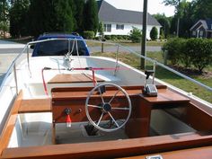 the steering wheel is attached to the deck of a boat that is parked on the side of the road