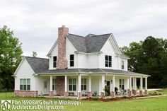 a large white house sitting on top of a lush green field