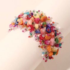 a bunch of beads that are on the side of a white wall and in front of a person's arm