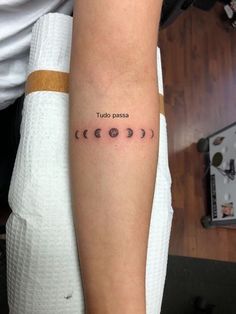 a woman with a tattoo on her arm that says, tudo passe and four phases