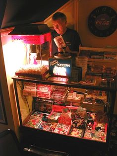 a man standing in front of a vending machine filled with candy and candies