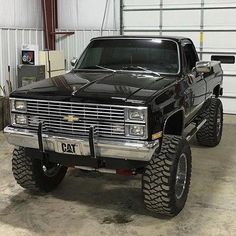 a large black truck parked in a garage