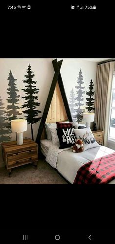 a bedroom decorated in black and white with trees painted on the wall