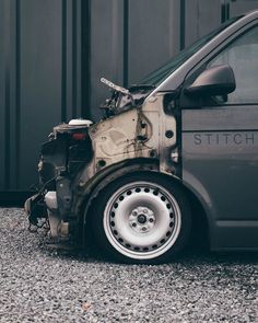 the front end of a car that has been badly torn off and is sitting on gravel