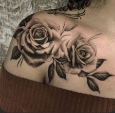 a woman's shoulder with two roses on it