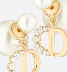 The elegant Dior Tribales earrings offer a new sleek, couture interpretation of an iconic House style. The hallmark pearls are adorned with the CD signature in gold-finish metal, embellished with small resin pearls in varying sizes adorning the letter C. Delicate and timeless, the earrings can be worn with creations from the 30 Montaigne line.. Designer Gold Drop Pearl Earrings, Luxury Pearl Earrings For Evening, Designer Gold Pearl Drop Earrings, Luxury Yellow Gold Pearl Earrings For Evening, Luxury Pearl White Drop Earrings, Luxury Pearl White Jewelry For Pierced Ears, Luxury Pearl White Formal Earrings, Luxury Pearl White Earrings For Formal Occasions, Luxury White Pearl Earrings