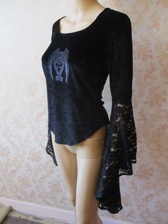 "vintage velvet gothic top with a round neck. The sleeves are elbow length with long asymetric lace cuffs.  There is a Gothic Angels motif in silver on the front and it has a slight stretch to it.  This is a gorgeous top in very good condition. Pit to pit;  18\" Length;  22\" Inside sleeve to wrist;  20\" Made by DARK STAR" Gothic Crew Neck Tops For Party, Gothic Tops For Fall Costume, Black Bohemian Tops For Halloween, Black Bohemian Top For Halloween, Fairy Grunge Long Sleeve Top For Party, Gothic Long Sleeve Top For Costume, Witchy Long Sleeve Tops For Party, Fitted Witchy Top For Halloween, Fitted Gothic Top For Halloween