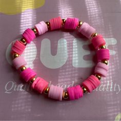 a pink and gold beaded bracelet on top of a table