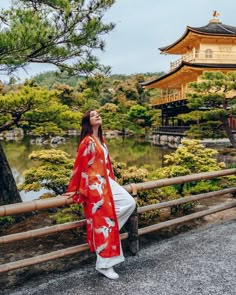 a woman in a red and white kimono looking up at the sky