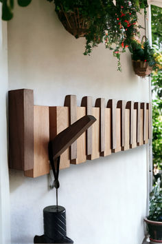 a wall mounted clock on the side of a building with plants hanging from it's sides