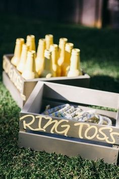 a wooden box filled with yellow bottles sitting on top of grass