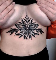 a woman's stomach with a butterfly tattoo on her belly and hands behind her back