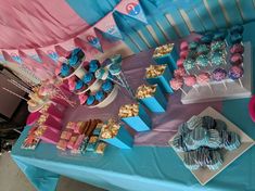 a table topped with blue and pink desserts