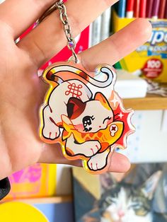 a hand holding a keychain with a cartoon dog on it's side