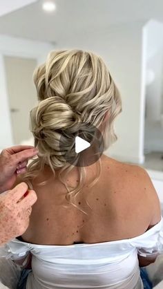 a woman is getting her hair styled in a low bun