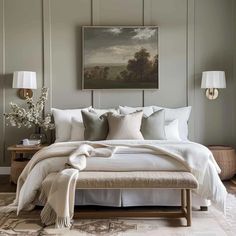 a bed with white linens and pillows in a gray room next to a painting on the wall