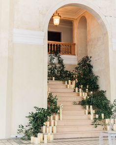 the stairs are lined with candles and potted plants