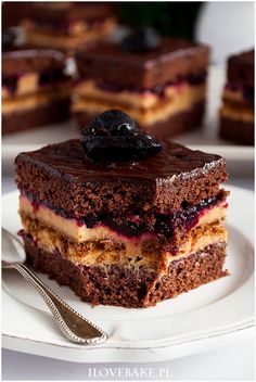 there is a piece of cake with chocolate and blueberries on the plate next to it