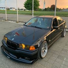 a black bmw is parked on the side of the road