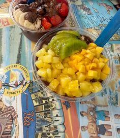 two bowls filled with different types of fruit on top of a colorful tablecloth covered table