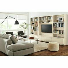 a living room filled with furniture and a flat screen tv sitting on top of a book shelf