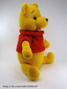 a crocheted winnie the pooh stuffed animal with a red scarf around it's neck