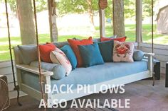 a porch swing with pillows on it